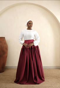 Nigerian fashion model wearing a white shirt and full maroon coloured skirt